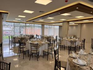 um salão de banquetes com mesas e cadeiras numa sala em Hotel Ambato em Ambato