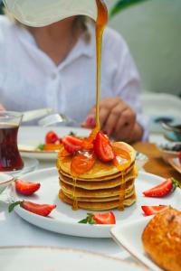 a person is pouring syrup on a stack of pancakes at Kassandra Boutique Hotel in Oludeniz