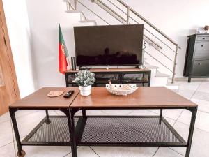 Μια τηλεόραση ή/και κέντρο ψυχαγωγίας στο Peniche master bedroom with sea view balcony, private bathroom, shared kitchen, swimming pool, surfing resort