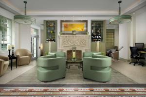 a living room with a fireplace and green chairs at Hilton Garden Inn Miami South Beach in Miami Beach
