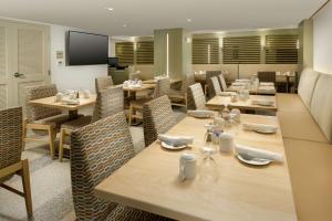 Hilton Garden Inn Miami South Beach في ميامي بيتش: مطعم بطاولات وكراسي خشبية وتلفزيون بشاشة مسطحة