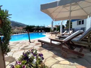 a pool with two lounge chairs and an umbrella at Villa Riviera in Stavros