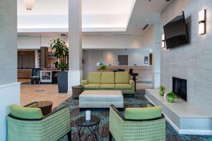 um átrio com um sofá e cadeiras e uma lareira em Hilton Garden Inn Orlando East - UCF Area em Orlando