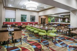 a dining room with tables and chairs on a colorful rug at Hilton Garden Inn San Antonio/Rim Pass Drive in San Antonio