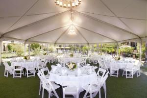 een tent met witte tafels en stoelen en een kroonluchter bij DoubleTree by Hilton Ontario Airport in Ontario
