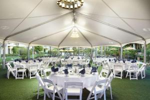 a marquee with white tables and chairs and a chandelier at DoubleTree by Hilton Ontario Airport in Ontario