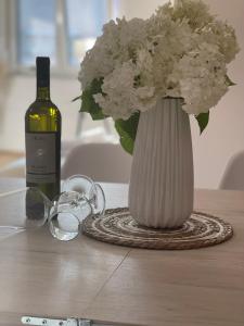 a bottle of wine and a vase of flowers on a table at R&B Apartment City Center in Ohrid
