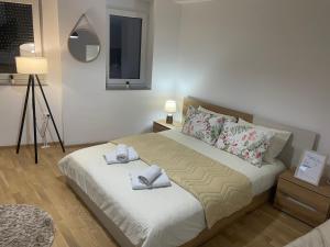 a bedroom with a bed with two towels on it at R&B Apartment City Center in Ohrid