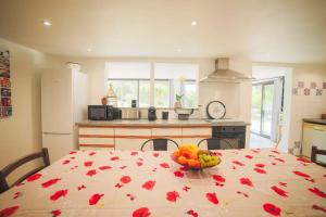 a kitchen with a table with a bowl of fruit on it at Maison du Riou, meublé de tourisme 3 etoiles vue sur colline avec piscine in Roquevaire