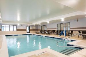 a large swimming pool with chairs and a table at DoubleTree by Hilton Schenectady in Schenectady