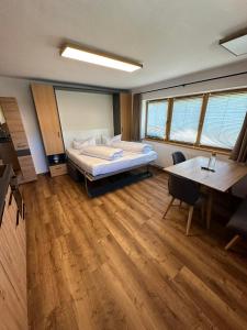 um quarto com uma cama, uma secretária e uma mesa em Apart Bader em Ehrwald