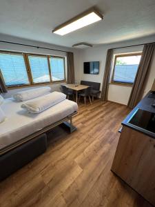 Zimmer mit einem Bett und einem Tisch in der Unterkunft Apart Bader in Ehrwald