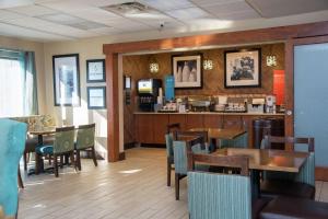 un restaurante con mesas, sillas y una barra en Hampton Inn Summersville en Summersville