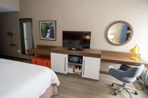 una camera d'albergo con letto e scrivania con TV di Hampton Inn Summersville a Summersville