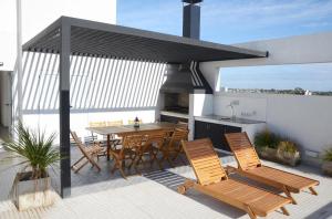 a patio with a table and chairs and a kitchen at Casa14 in La Plata