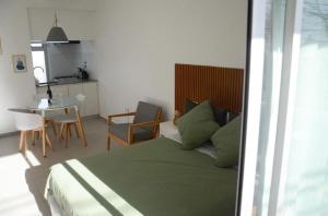 a bedroom with a bed and a table and a kitchen at Casa14 in La Plata