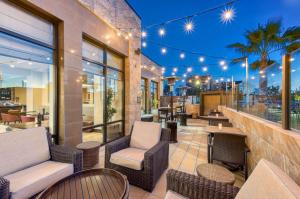 bar z wiklinowymi krzesłami i stołami na patio w obiekcie Hilton Garden Inn Irvine/Orange County Airport w mieście Irvine