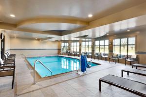 a pool in a hotel lobby with tables and chairs at Hampton Inn and Suites Monroe in Monroe