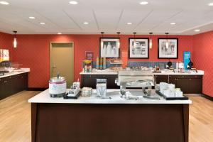 a salon with red walls and a counter top withmetics at Hampton Inn and Suites Monroe in Monroe