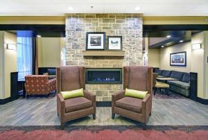 a lobby with two chairs and a fireplace at Hampton Inn & Suites Milwaukee/Franklin in Franklin