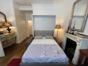 Bett in einem Zimmer mit Kamin in der Unterkunft Jefferson House in London