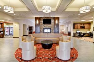 a lobby with a couch and a table and chairs at Homewood Suites by Hilton Woodbridge in Woodbridge