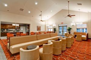 a lobby with a large couch and chairs at Homewood Suites by Hilton Woodbridge in Woodbridge