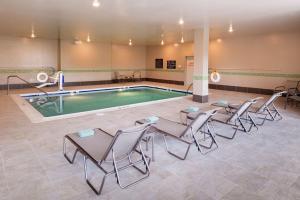 a pool with chairs and a table in front of it at Hilton Garden Inn Bristol in Bristol