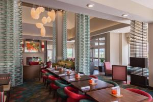 a restaurant with wooden tables and red chairs at Hilton Garden Inn Bristol in Bristol