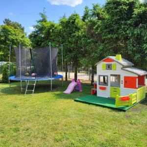 a playground with a play house and a trampoline at Apartamenty Agro Roś in Pisz
