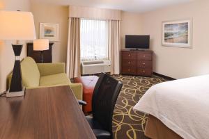 een hotelkamer met een bed, een bureau en een televisie bij Hampton Inn Omaha Midtown-Aksarben in Omaha