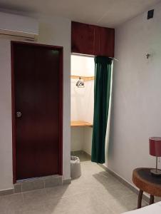 een kamer met een deur en een groen gordijn bij Alojamiento Ya'ax Nah in Playa del Carmen