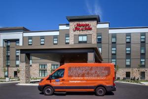 an orange van parked in front of a building at Hampton Inn & Suites Milwaukee West in West Allis