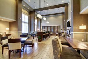 a dining room with a large table and chairs at Hampton Inn & Suites Milwaukee West in West Allis