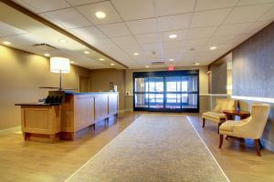 a lobby with a waiting room with a desk and chairs at Hampton Inn & Suites Milwaukee West in West Allis