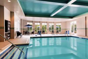 a large swimming pool in a hotel with a dining room at Hilton Garden Inn Lenox Pittsfield in Pittsfield