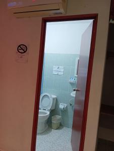 a bathroom with a toilet and a door open at Alojamiento Ya'ax Nah in Playa del Carmen