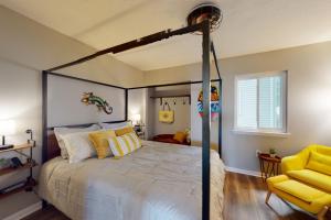 a bedroom with a canopy bed and a yellow chair at AL-BE Vacation Villas # 5 in Ocean City