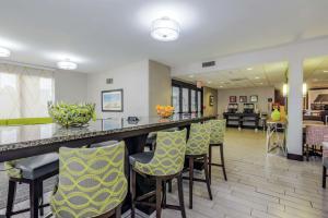 a lobby with a bar with yellow and green chairs at Hampton Inn Tampa International Airport/Westshore in Tampa