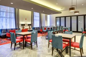 un restaurante con mesas, sillas y ventanas en Hampton Inn & Suites - Roanoke-Downtown, VA en Roanoke