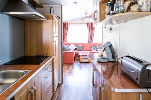 een keuken en een woonkamer met een rode bank bij mobil home in Hyères