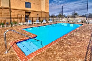 a swimming pool with chairs and a building at Hampton Inn Clarksdale, Ms in Clarksdale