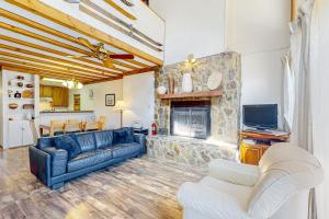 uma sala de estar com um sofá e uma lareira de pedra em Timbers Four em Angel Fire