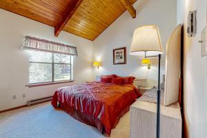 um quarto com uma cama e uma grande janela em Timbers Four em Angel Fire