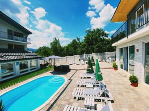 a patio with lounge chairs and a swimming pool at Green Hill Villa & SPA in Călimăneşti