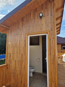 un bâtiment en bois avec des toilettes sur une terrasse dans l'établissement Glamping Agapia Agapescu, à Agapia
