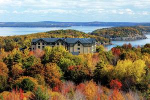 a house on top of a hill with trees and water at Hampton Inn Bar Harbor in Bar Harbor
