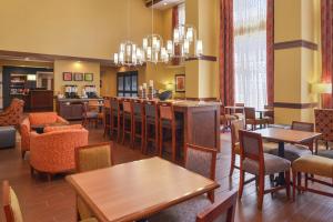 a restaurant with tables and chairs and a bar at Hampton Inn & Suites by Hilton Lonoke in Lonoke