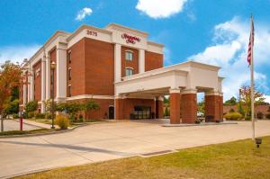 um edifício de tijolos vermelhos com uma bandeira em frente em Hampton Inn Hernando, MS em Hernando