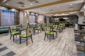 a waiting room with tables and chairs in a restaurant at Hampton Inn Hernando, MS in Hernando